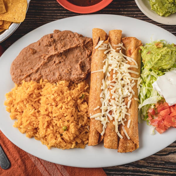Taqueria Los Agaves' Mexican dish with taquitos, rice, refried beans, guacamole, sour cream, and salsa.