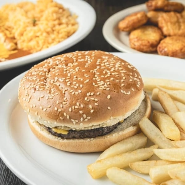 A cheeseburger with fries, rice, and chicken nuggets on white plates.